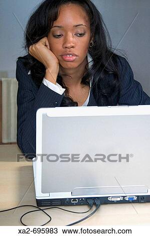 Stock Image - Portrait of woman bored at work. Fotosearch