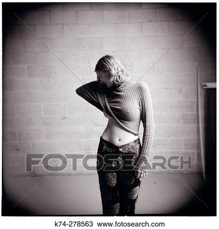 Stock Image - Portrait of Woman Lifting Sweater. Fotosearch