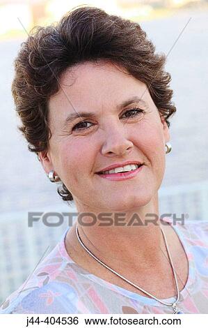 Stock Photograph - Portrait of woman smiling outdoor. Fotosearch