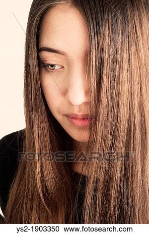 Portrait of young adult female with pensive expression View Large Photo Image Stock Image - Portrait of young adult female with pensive expression. Fotosearch