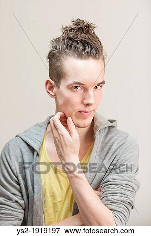Portrait of young adult man with moody expression wearing casual clothes View Large Photo Image Stock Photo - Portrait of young adult man with moody expression wearing casual clothes. Fotosearch
