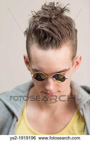 Portrait of young adult man with moody expression wearing shades and casual clothes View Large Photo Image Stock Photograph - Portrait of young adult man with moody expression wearing shades and casual clothes. Fotosearch