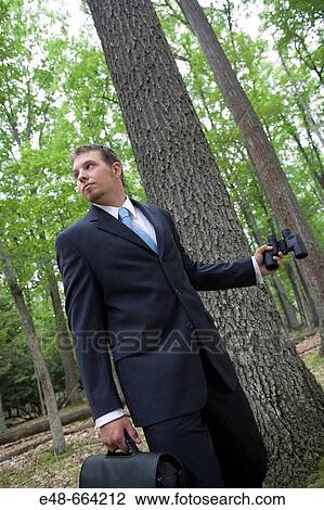 Portrait of young businessman in forest with binoculars View Large Photo Image Stock Image - Portrait of young businessman in forest with binoculars. Fotosearch