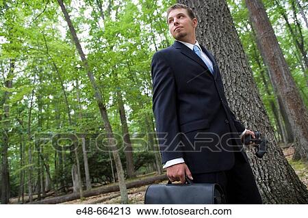 Portrait of young businessman in forest with binoculars View Large Photo Image Stock Image - Portrait of young businessman in forest with binoculars. Fotosearch