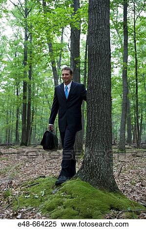 Portrait of young businessman in forest with cellular phone View Large Photo Image Stock Photography - Portrait of young businessman in forest with cellular phone. Fotosearch