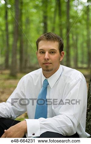 Portrait of young businessman sitting in forest View Large Photo Image Stock Image - Portrait of young businessman sitting in forest. Fotosearch