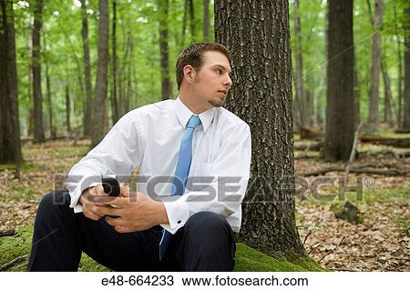 Portrait of young businessman sitting in forest View Large Photo Image Stock Image - Portrait of young businessman sitting in forest. Fotosearch