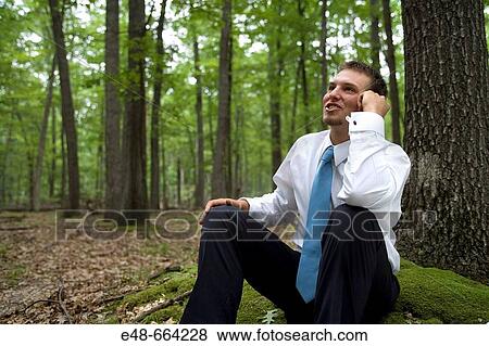 Portrait of young businessman sitting in forest View Large Photo Image Stock Photo - Portrait of young businessman sitting in forest. Fotosearch