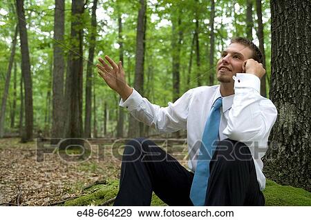 Portrait of young businessman sitting in forest View Large Photo Image Stock Photo - Portrait of young businessman sitting in forest. Fotosearch