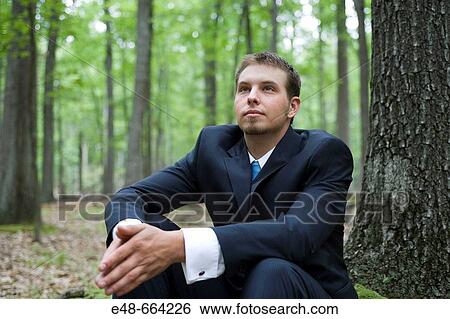 Portrait of young businessman sitting in forest View Large Photo Image Stock Photograph - Portrait of young businessman sitting in forest. Fotosearch