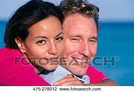 Stock Image - portrait of young couple at the beach. Fotosearch