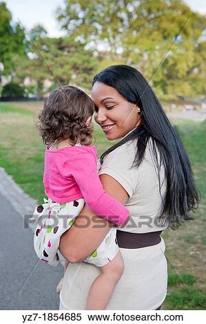 Portrait of young latino mother and daughter looking at each other in park View Large Photo Image Stock Photography - Portrait of young latino mother and daughter looking at each other in park. Fotosearch