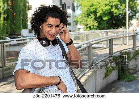 Stock Photograph - portrait of young male student with a phone in the town.. Fotosearch
