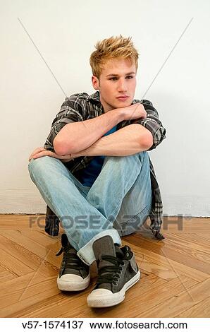 Portrait of young man sitting on the floor View Large Photo Image Stock Photo - Portrait of young man sitting on the floor. Fotosearch
