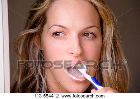 Portrait of young woman brushing her teeth View Large Photo Image Stock Image - Portrait of young woman brushing her teeth. Fotosearch