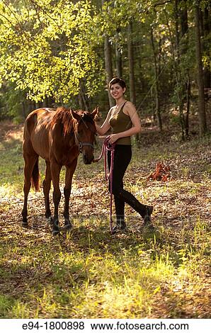 Portrait of young woman in a pasture with a horse View Large Photo Image Stock Photo - Portrait of young woman in a pasture with a horse. Fotosearch