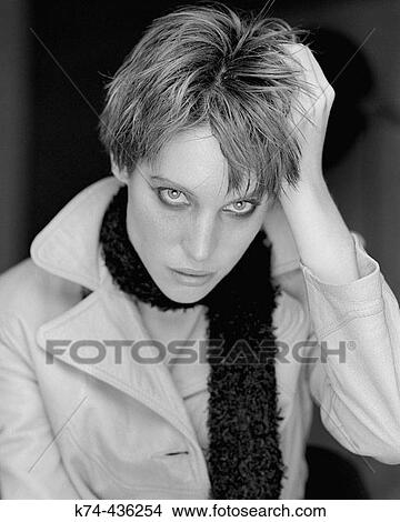 Picture - Portrait of young woman in trench coat and scarf. Fotosearch