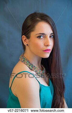 Stock Image - Portrait of young woman looking at the camera.. Fotosearch