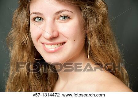 Portrait of young woman smiling and looking at the camera. Close view. View Large Photo Image Stock Image - Portrait of young woman smiling and looking at the camera. Close view.. Fotosearch