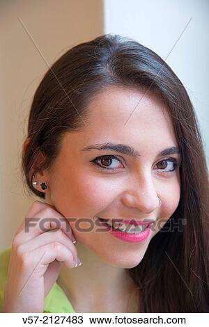 Portrait of young woman smiling and looking at the camera. Close view. View Large Photo Image Stock Image - Portrait of young woman smiling and looking at the camera. Close view.. Fotosearch