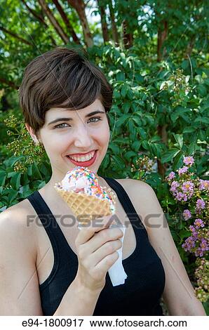 Stock Photo - Portrait of young woman with an ice cream cone. Fotosearch
