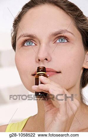 portrait of young woman with blue eyes, looking upwards and smelling a small bottle of essential oils, phytotherapy View Large Photo Image Stock Image - portrait of young woman with blue eyes, looking upwards and smelling a small bottle of essential oils, phytotherapy. Fotosearch