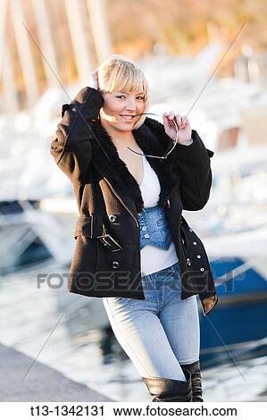 Posing in front of numerous boats with glasses in her hand handsome young woman View Large Photo Image Stock Image - Posing in front of numerous boats with glasses in her hand handsome young woman. Fotosearch