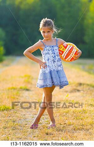 Stock Photography - Posing with a ball in hand 6 years old girl. Fotosearch