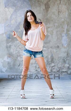 Stock Photo - Posing with glasses in hand young woman. Fotosearch