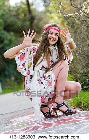 Posing with her hands and fingers spread young woman in a flowery dress View Large Photo Image Stock Image - Posing with her hands and fingers spread young woman in a flowery dress. Fotosearch