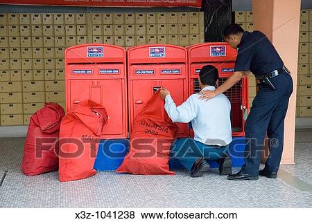 Postman emptying letter boxes at the central Post Office in Johor Baru Malaysia View Large Photo Image Stock Photo - Postman emptying letter boxes at the central Post Office in Johor Baru Malaysia. Fotosearch