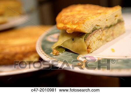 Stock Image - Potato omelette, cheese and green peppers. Pintxos, San Sebastian (Donostia), Basque Country, Spain. Fotosearch