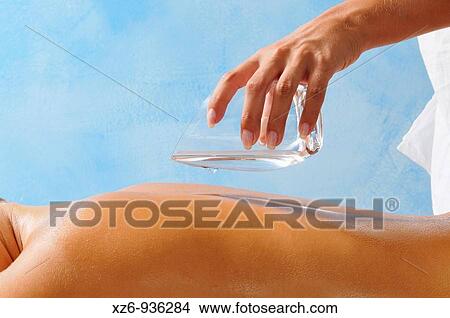 Pouring essential oil on the back in the SPA View Large Photo Image Picture - Pouring essential oil on the back in the SPA. Fotosearch