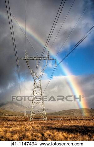 Power pylons, rainbow forms as evening sun lights up rain clouds, Mackenzie country, Canterbury, New Zealand View Large Photo Image Picture - Power pylons, rainbow forms as evening sun lights up rain clouds, Mackenzie country, Canterbury, New Zealand. Fotosearch