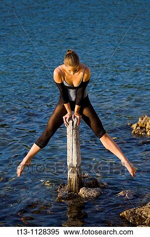 Stock Photography - Practicing on a wooden pole, gracious ballerina. Fotosearch