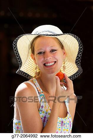 Prague. Czech Republic. Portrait of a young woman smiling eating a strawberry. View Large Photo Image Stock Image - Prague. Czech Republic. Portrait of a young woman smiling eating a strawberry.. Fotosearch