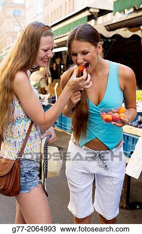 Prague. Czech Republic. two young women in a market eating fresh fruits. View Large Photo Image Stock Image - Prague. Czech Republic. two young women in a market eating fresh fruits.. Fotosearch