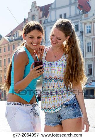 Prague. Czech Republic. Two young women in Old Town Square of Prague watching photos on a smart phone. View Large Photo Image Stock Photo - Prague. Czech Republic. Two young women in Old Town Square of Prague watching photos on a smart phone.. Fotosearch