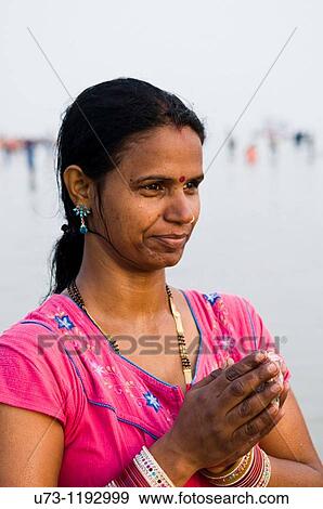 Stock Photo - Praying by the Ganges river.. Fotosearch