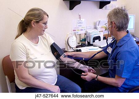 pregnant lady at the doctors having her pre natal checkup, nurse taking her blood pressure View Large Photo Image Picture - pregnant lady at the doctors having her pre natal checkup, nurse taking her blood pressure. Fotosearch