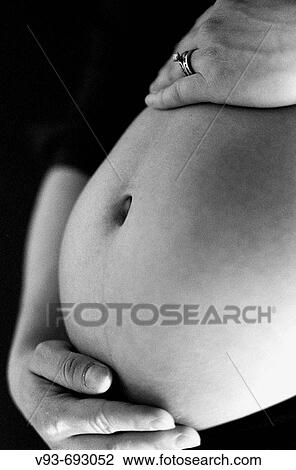 Stock Image - pregnant mother with wedding rings. Fotosearch