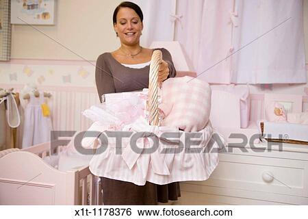 Pregnant woman holding basket of baby clothes. View Large Photo Image Stock Photograph - Pregnant woman holding basket of baby clothes.. Fotosearch