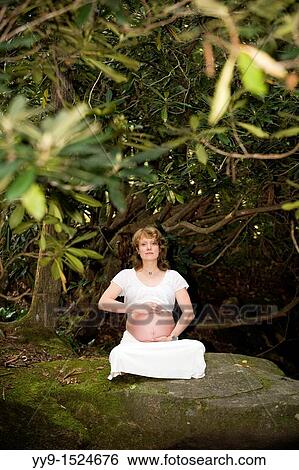 Stock Photograph - Pregnant Woman holding belly - Pisgah National Forest - near Brevard, North Carolina, USA. Fotosearch