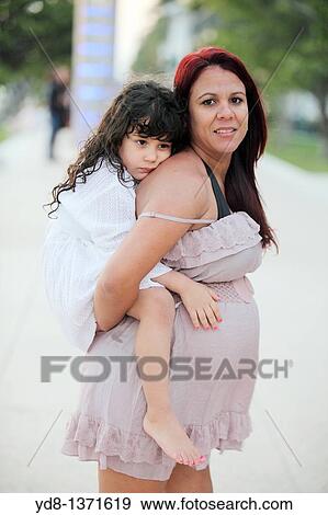 Pregnant woman holding her child in Miami Beach, Florida, USA View Large Photo Image Stock Photo - Pregnant woman holding her child in Miami Beach, Florida, USA. Fotosearch
