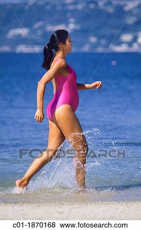 Stock Photo - Pregnant woman jogging on beach. Fotosearch