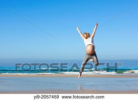 pregnant woman jumping on the beach. View Large Photo Image Stock Photo - pregnant woman jumping on the beach.. Fotosearch