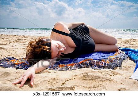 Pregnant woman laying down on the beach by the sea View Large Photo Image Stock Photo - Pregnant woman laying down on the beach by the sea. Fotosearch