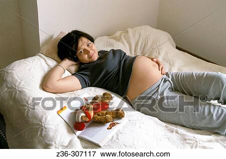 Pregnant woman laying in bed View Large Photo Image Stock Photo - Pregnant woman laying in bed. Fotosearch
