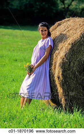 Pregnant woman leaning back against a bale of hay View Large Photo Image Stock Photograph - Pregnant woman leaning back against a bale of hay. Fotosearch