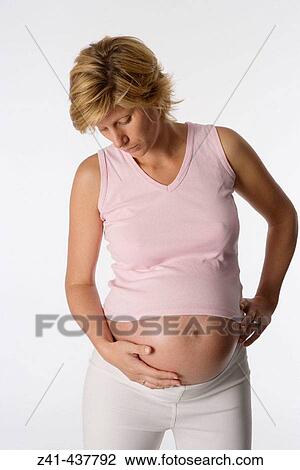 Pregnant woman looking at her belly View Large Photo Image Stock Image - Pregnant woman looking at her belly. Fotosearch